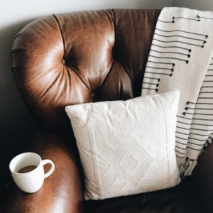 Cozy home chair with white pillow and cozy blanket