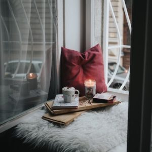 Cozy home corner with candle and books