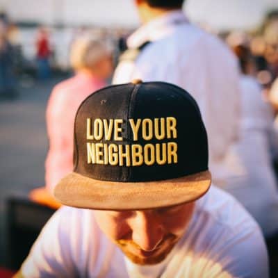 man wearing hat that says love your neighbor