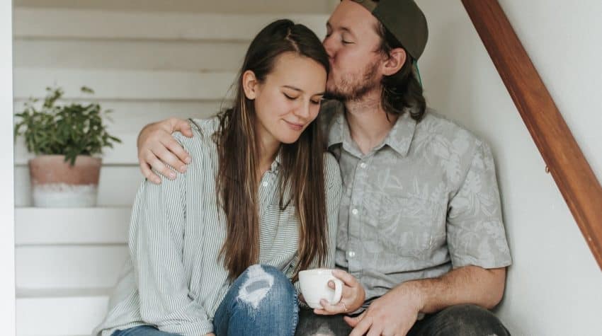 Husband kissing wife on head