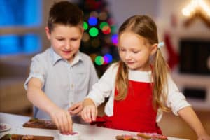 boy and girl decorating cookies as a Christmas tradition