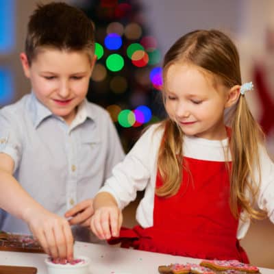 boy and girl decorating cookies as a Christmas tradition