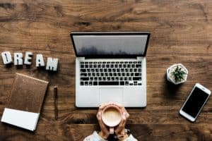 woman with laptop holding coffee