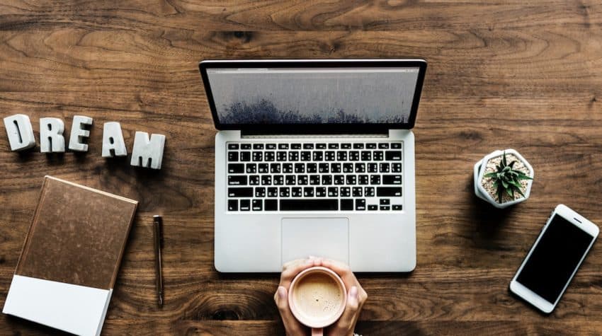 woman with laptop holding coffee