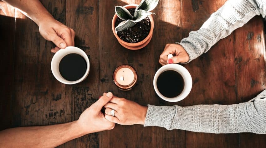 married couple holding hands on date at home