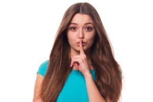 brunette woman saying "Shh"