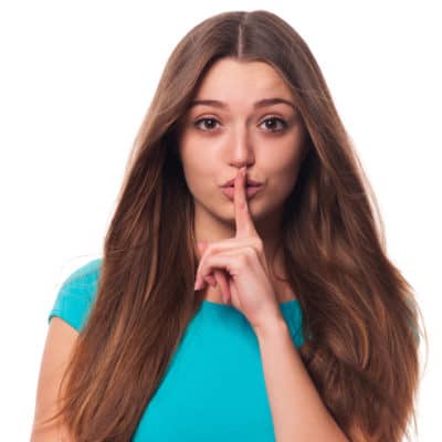 brunette woman saying "Shh"