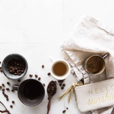 white counter with cups of coffee, coffee beans, and coffee accessories