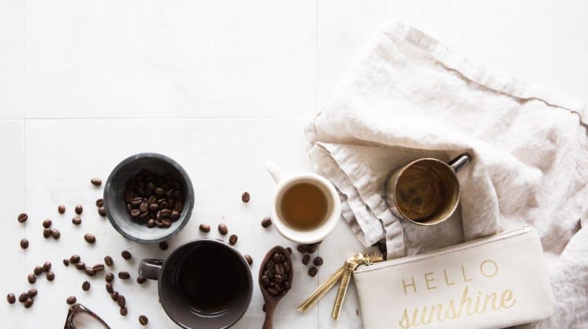 white counter with cups of coffee, coffee beans, and coffee accessories