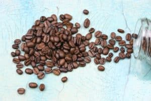 coffee beans spread out on turquoise countertop