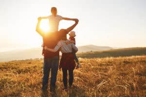 happy family on vacation staring at sunset