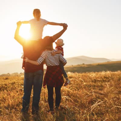 happy family on vacation staring at sunset