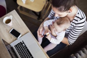 busy mom working with baby on lap