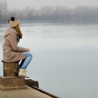 Woman staring sadly at a lake