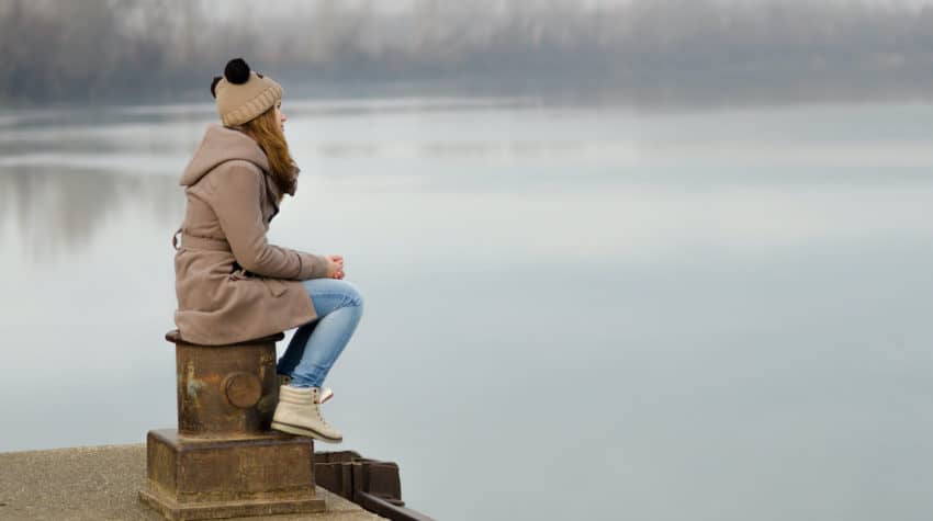 Woman staring sadly at a lake