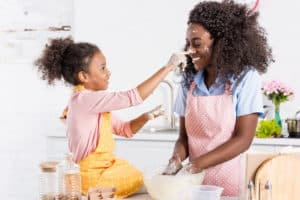 mom and girl having fun in kitchen