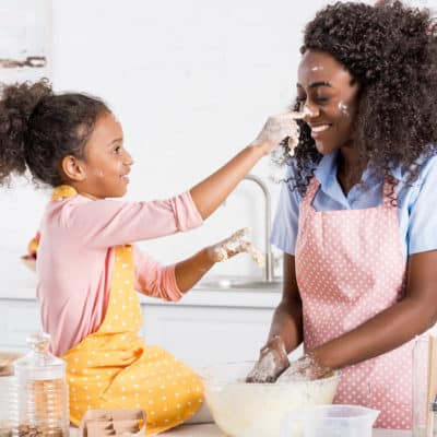 mom and girl having fun in kitchen