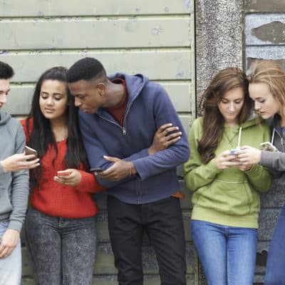 teenagers looking at their phones