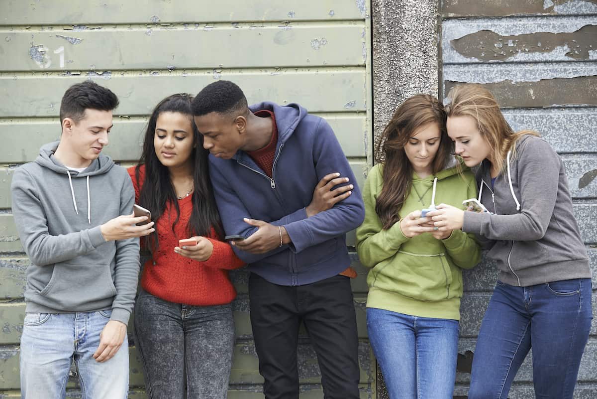 teenagers looking at their phones