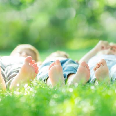 happy family with bare feet lying on green grass in spring