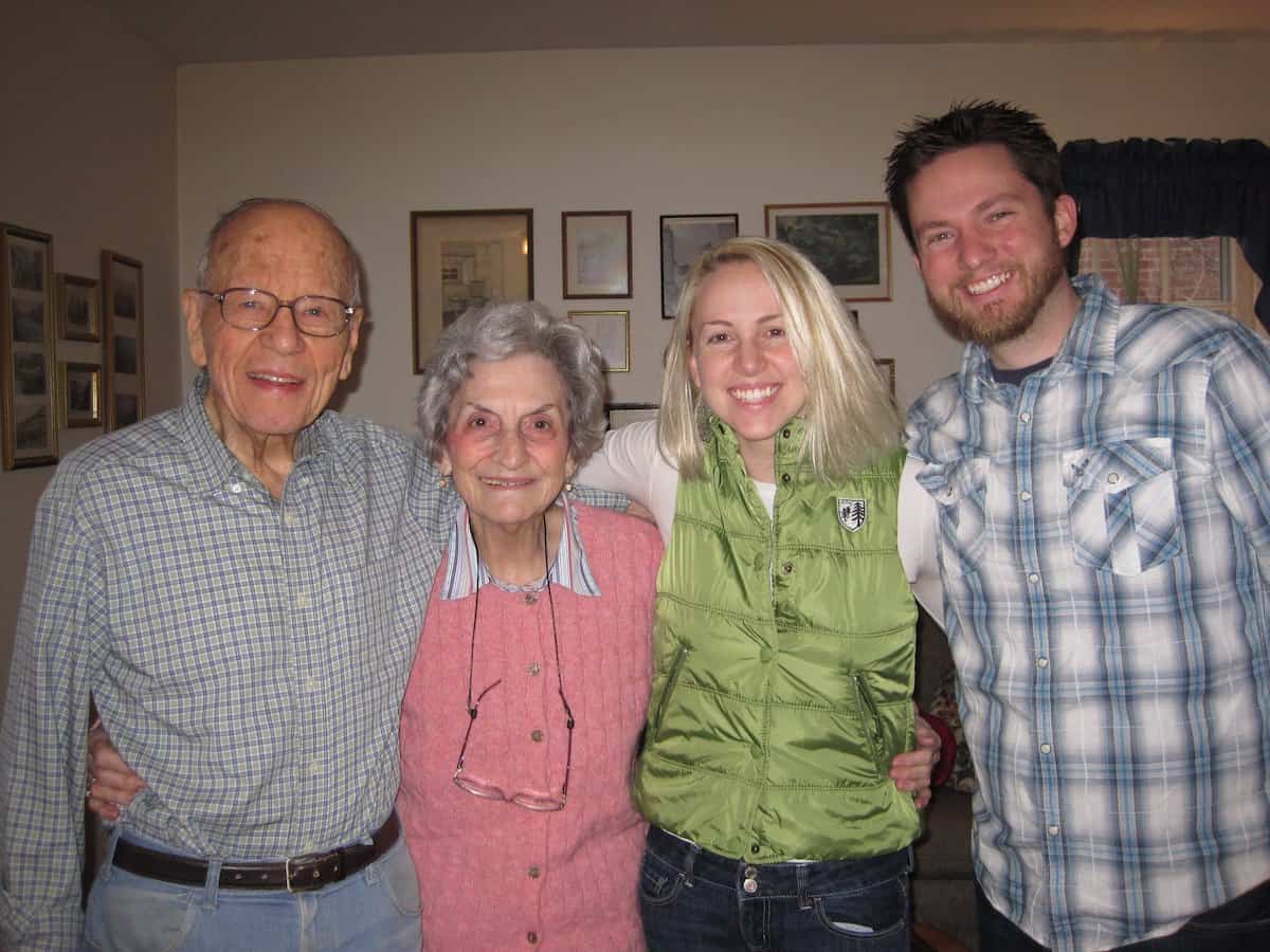 Grandparents smiling and arm around young married couple