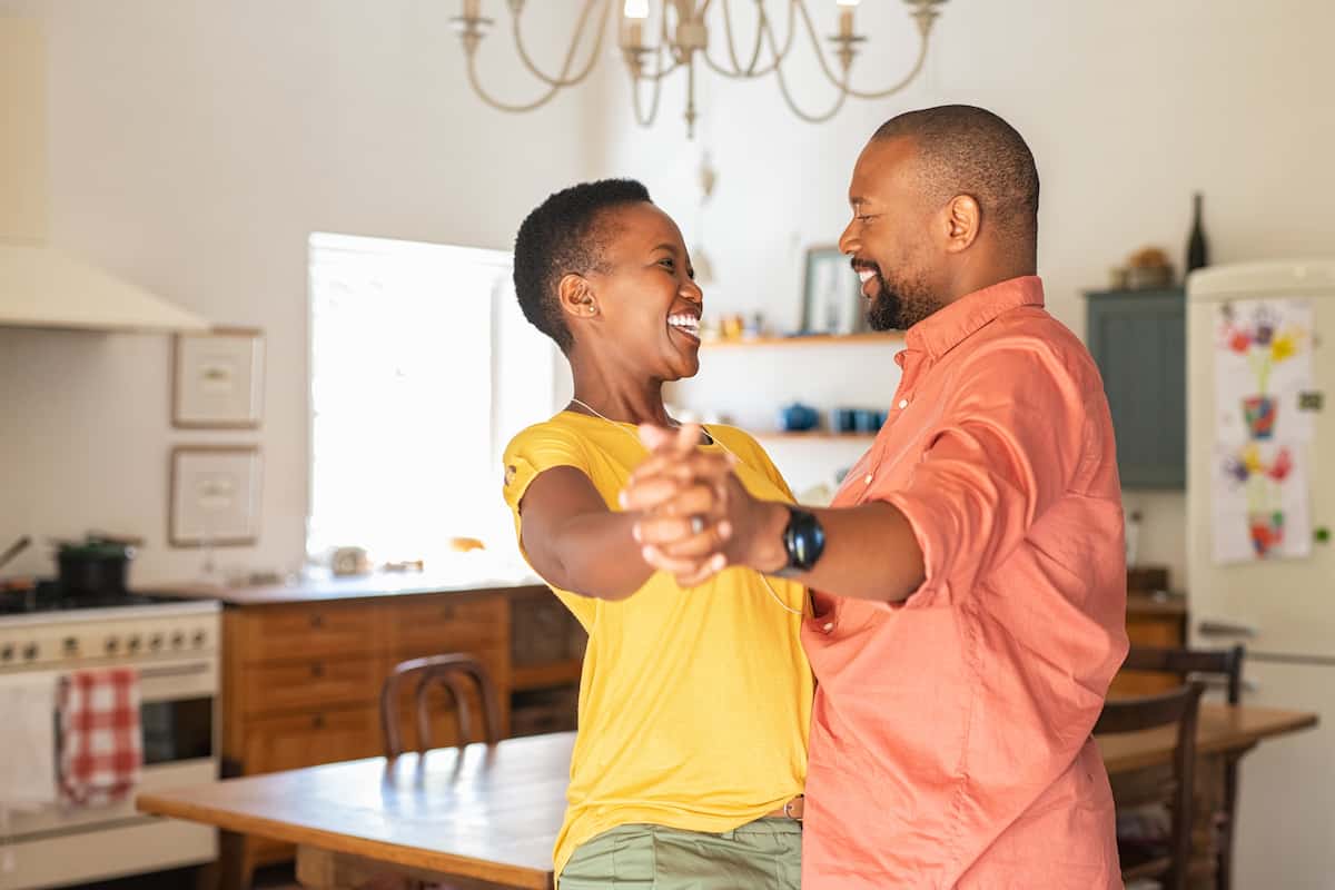 Husband and wife dancing in their kitchen.